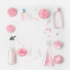 Wall Mural - pastel pink cosmetic product setting flat lay with flowers on white desk background, top view, frame