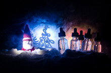 Electronic Cigarette With Vape Liquids And Christmas Decorations On Bokeh Lights Background