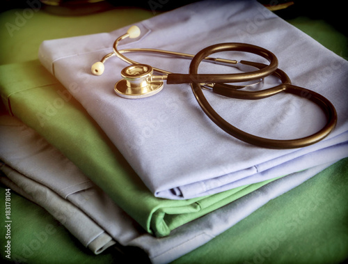 Fotografía Stethoscope about blue and green nurse uniform in a hospital, conceptual image