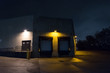 Dark and scary city warehouse loading dock and entrance door at night.