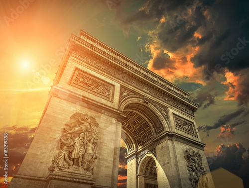 Plakat Arc de Triomphe w Paryżu pod niebem z chmurami. Jeden z symboli o
