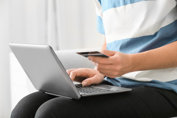 Poster - Young woman with credit card working on laptop, closeup