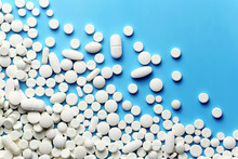 White Medicine Pills On A Blue