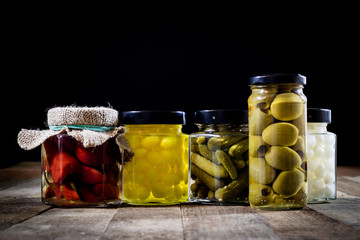 Mortar, vegetables in jars for the winter, wooden table in the old kitchen