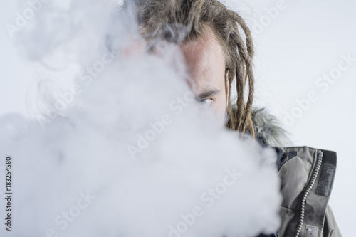 Fotografie, Obraz Man dreadlocks smoking electronic cigarette .