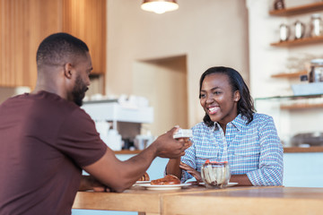 Wall Mural - Young African man giving a present to his smiling girlfriend 