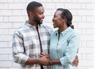 Wall Mural - Affectionate young African couple standing together in the city