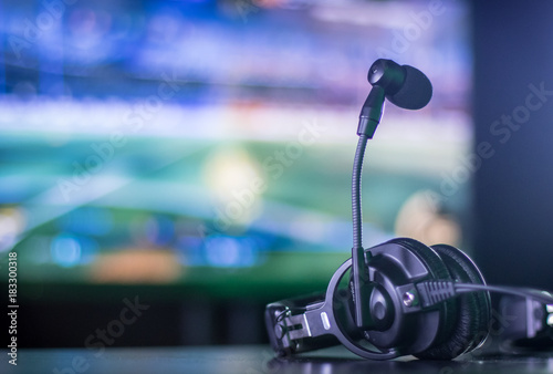 Photographie Headset resting on table with screen in background