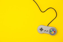 Retro Computer Gaming Controller On A Bright Yellow Background