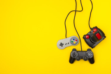retro computer gaming controllers on a bright yellow background