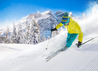 Skier skiing downhill in high mountains