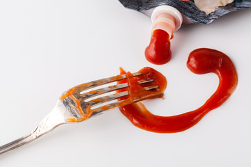 red ketchup splashes on white background, tomato pure texture with fork