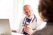 © Halfpoint - Doctor with laptop talking to a senior woman in office.