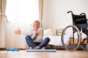 Wall Mural - Senior man doing exercise at home.