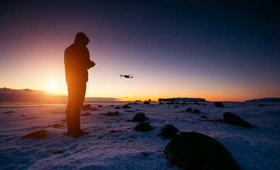 Wall Mural - drone pilot with unmanned aircraft in beautiful sunset ligt. modern technology and outdoor activity