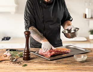 Man cooking meat steak on kitchen