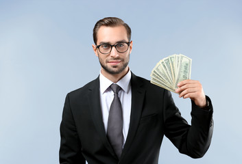 Sticker - Handsome businessman with dollar bills on light background