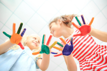 Wall Mural - Cute little girls with painted hands in kindergarten