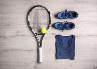 Poster - Tennis racket, ball, clothes and shoes on wooden background