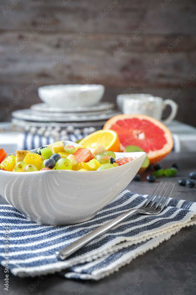 Bowl with delicious fruit salad on table