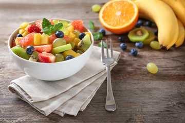 Wall Mural - Bowl with delicious fruit salad on table