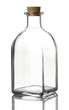 Empty transparent glass bottle of a square shape with a cork stopper on a reflective surface, isolated on a white background.