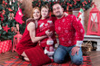 © Gribanov - Family portrait - mother, father and son in red sweaters at the Christmas tree