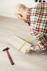 Wall Mural - Preparing of man for laying laminate at home