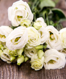 Fototapeta Tulipany - White roses on a wooden background
