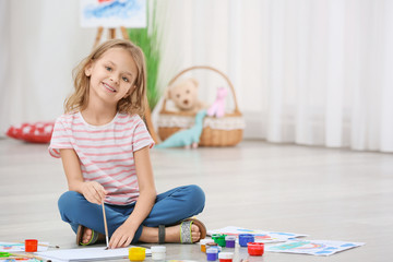 Poster - Little girl painting while sitting on floor at home