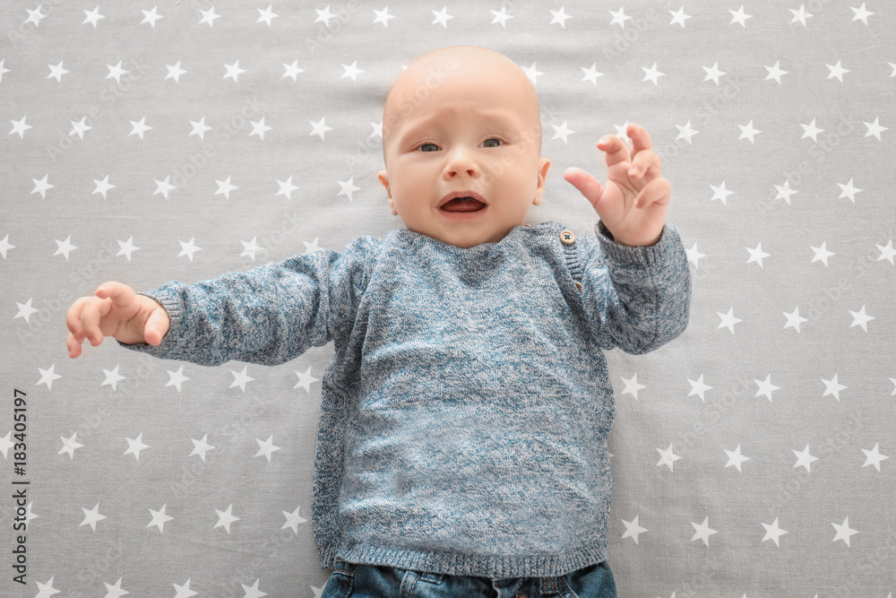 Cute boy on bedsheet