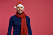 © SHOTPRIME STUDIO - man smiling on a red background, free space for copy, christmas