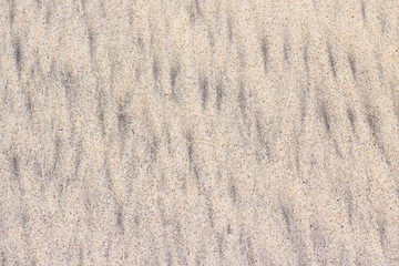 Mixed yellow coral and black volcanic sand in the beach of Bali, Indonesia