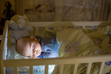 Wall Mural - Adorable newborn baby boy, sleeping in crib at night