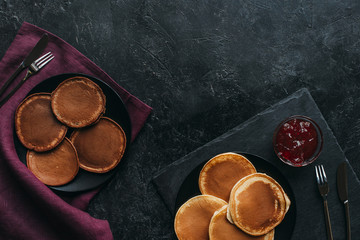 Wall Mural - top view of various pancakes in plates on black surface
