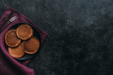 Wall Mural - top view of plate of chocolate pancakes on black surface