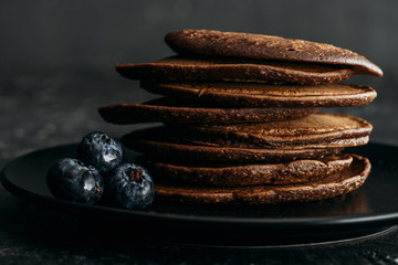 Wall Mural - close-up shot of stack of chocolate pancakes with blueberries