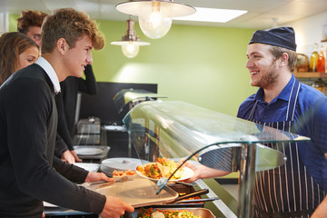 Wall Mural - Teenage Students Being Served Meal In School Canteen