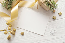 Mockup Christmas Greeting Card Top View And Gold Star, Flatlay On A White Wooden Background With A Ribbon, With Place For Your Text
