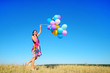 © Володимир Гончарук - Beautiful, cheerful young woman in a bright dress with colorful balloons  on a field with a blue sky in the summer. Warm sunny summer day with light breeze.