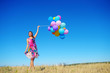 © Володимир Гончарук - Beautiful, cheerful young woman in a bright dress with colorful balloons  on a field with a blue sky in the summer. Warm sunny summer day with light breeze.