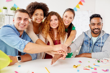 Canvas Print - happy business team at office party holding hands