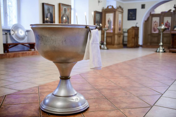 Wall Mural - Bath for the sacrament of baptism in the Christian Church. Baptismal Font - a large bowl-shaped receptacle. Church utensils for the sacraments and rites. 