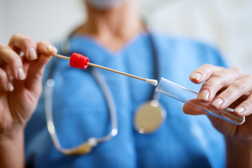 close up of nurses hands holding buccal cotton swab and test tube ready to collect dna from the cell