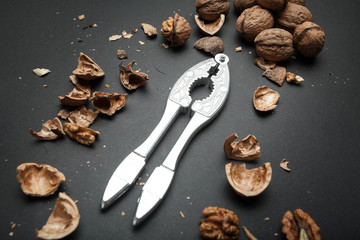 Wall Mural - The process of opening the core of the walnut and whole walnuts on a black background.