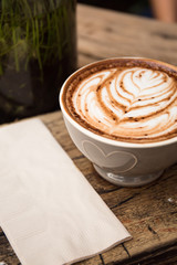 Wall Mural - Cup of hot latte art coffee on wooden table