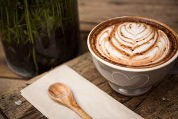 Wall Mural - Cup of hot latte art coffee on wooden table