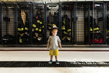 Full Length Of Boy Wearing Firefighter's Helmet While Standing At Fire Station