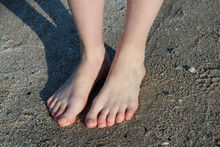 Shy Girl Feet Standing In A Sand.