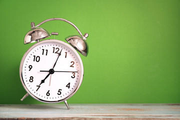 Wall Mural - Retro dancing alarm clock on wooden board with green background